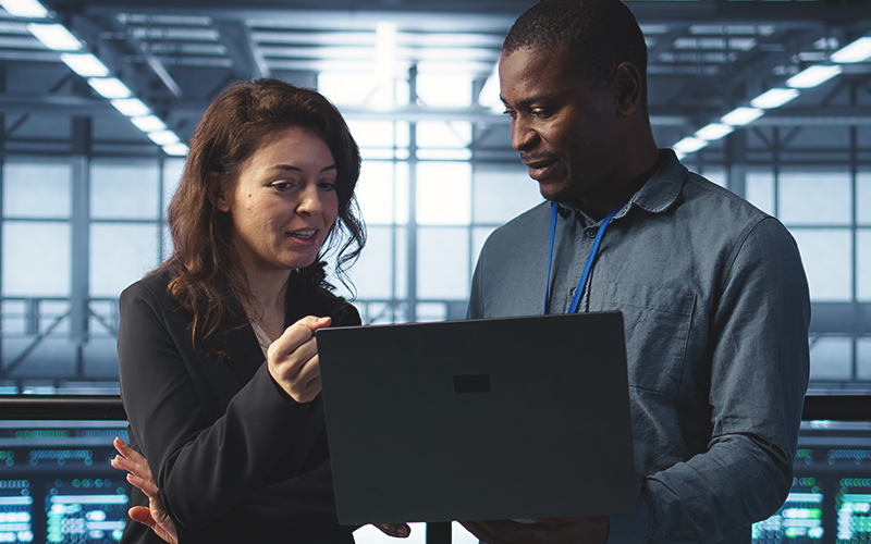 People in data center on laptop.