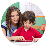 Female teacher helping student on tablet computer