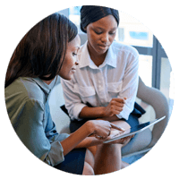 Two business women looking at tablet device