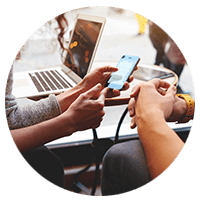 Close up of multiple mobile devices on table and in hands