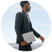 man in suit walking outside with a surface device in hand