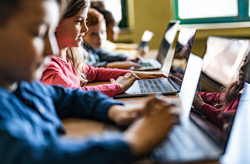 Students working on laptops in classroom