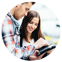 Man and woman look at tablet while on travel