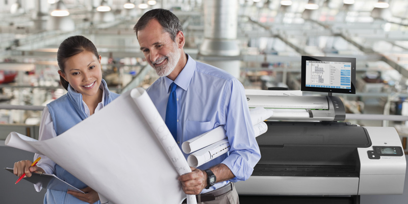 Businessman holds and shares large printed pages with woman