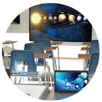 Desks in classroom with large monitors to engage students.
