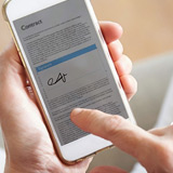 Digital transaction management Close up of finger applying e-signature using electronic signature software with smart phone