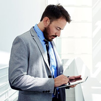 Hybrid cloud infrastructure Business man using tablet to check email while off site