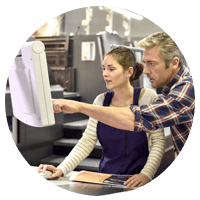 Two business manufactures review project off monitor at service station in manufacturing lab