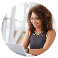 Smiling businesswoman works on laptop computer