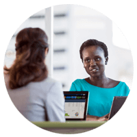 Two businesswomen working collaboratively together on mobile devices offsite