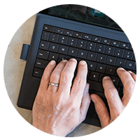 Hands typing on a laptop keyboard