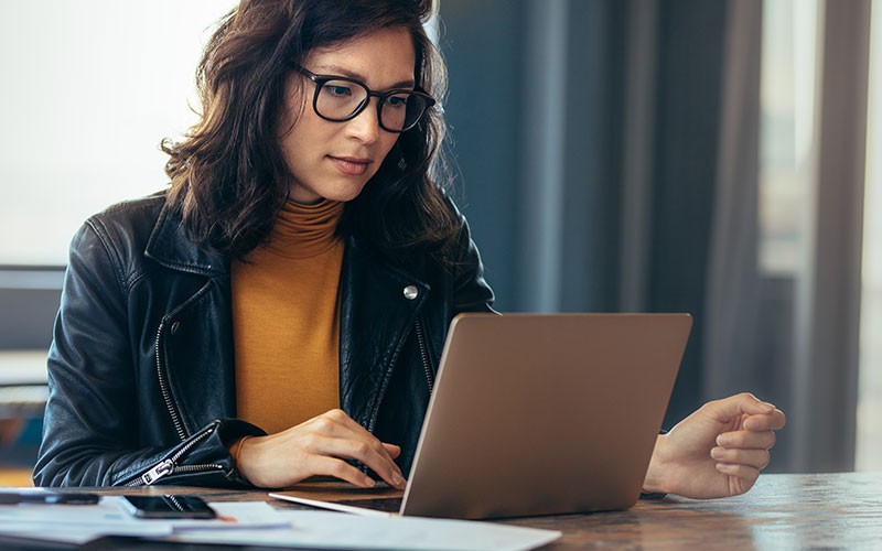 Business woman uses laptop computer at work