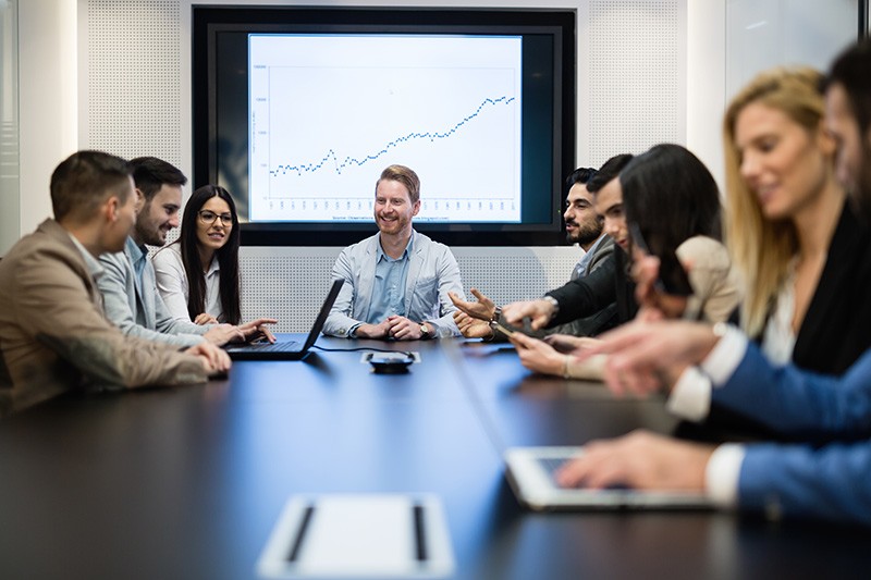 IT executives in business meeting discussing currency