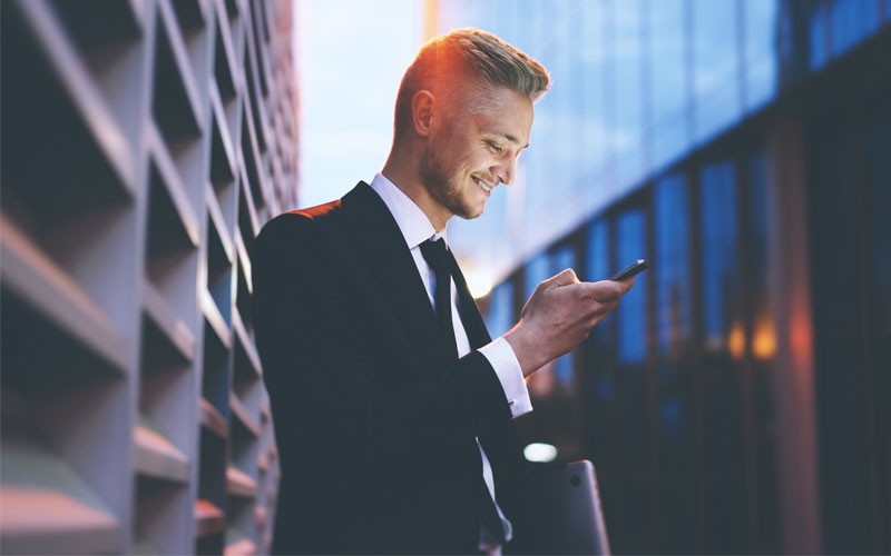 Hybrid cloud solutions Business man using mobile device outside
