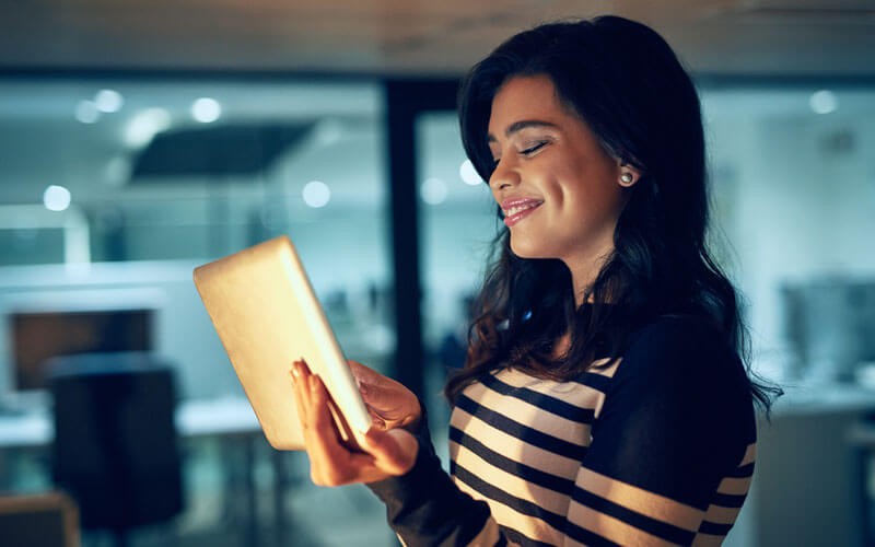 Smiling IT woman using tablet in office setting