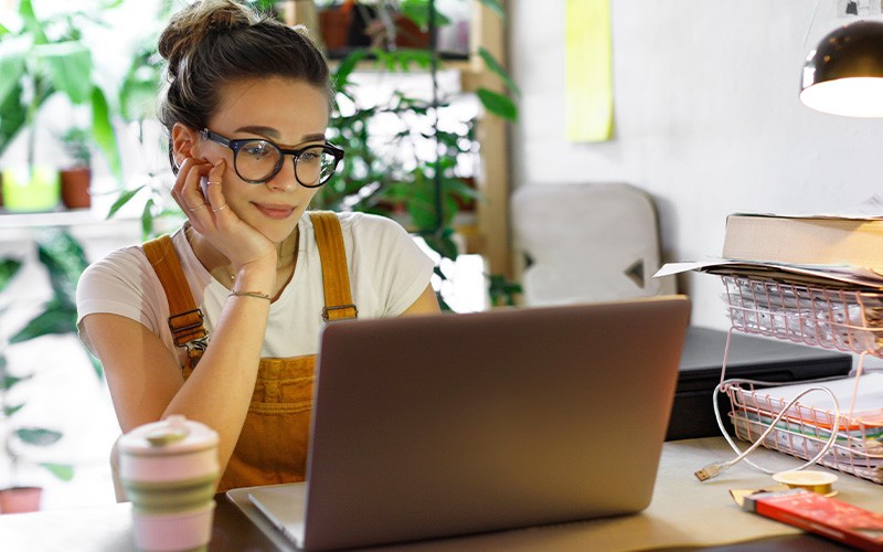 woman thinking in front of laptop