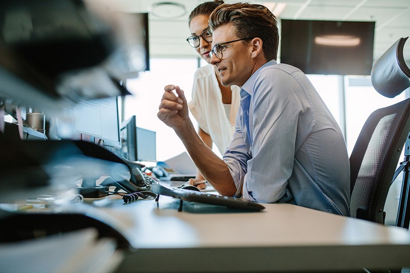 Business man at desk using desktop and monitor device