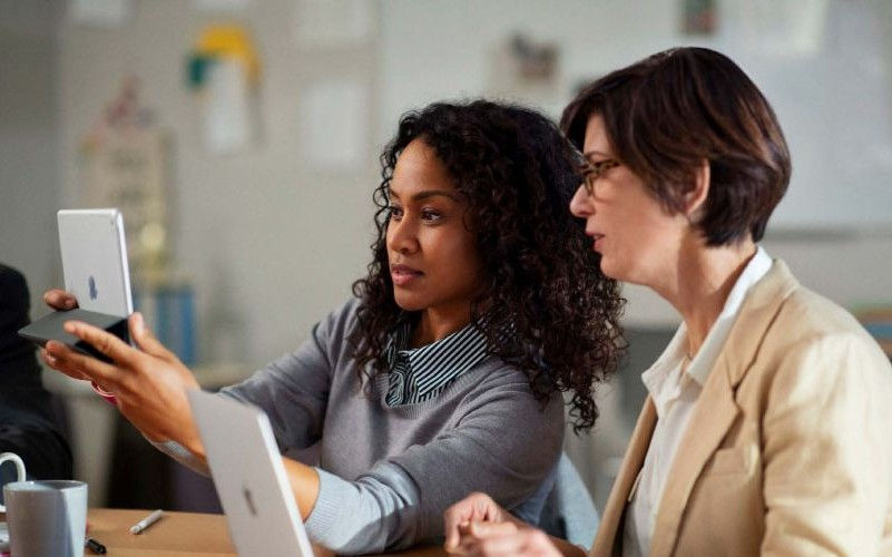 two woman using ipad