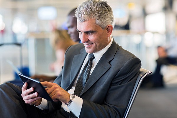 Business man working from airport off tablet