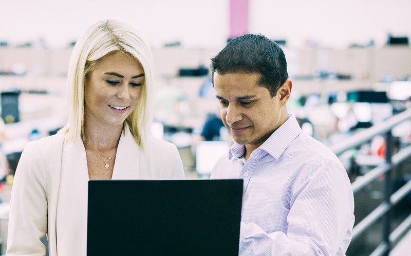 Business professionals standing with laptop computer