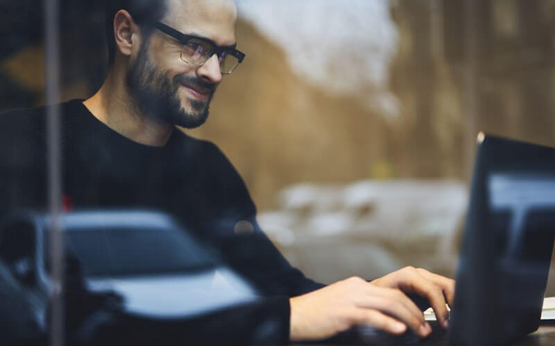 Manage your data down to the user level Man smiling on laptop