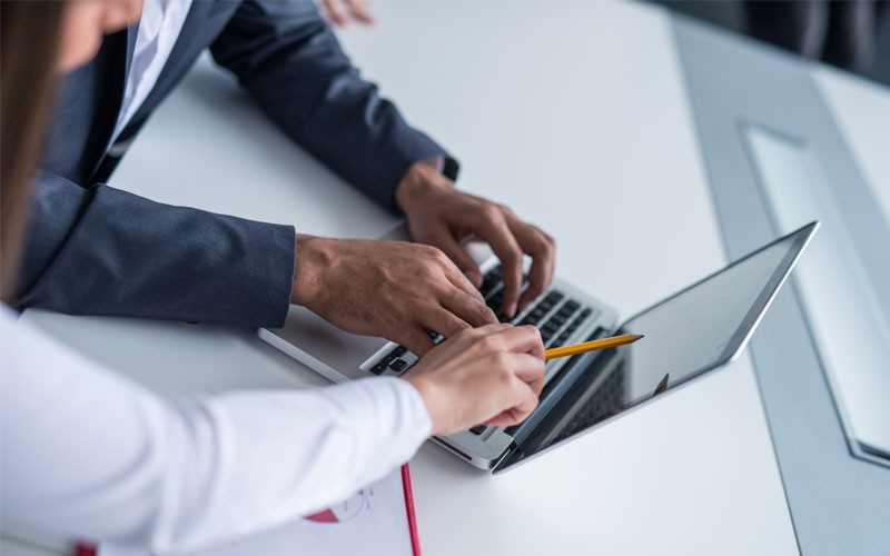 Employees pointing at laptop screen