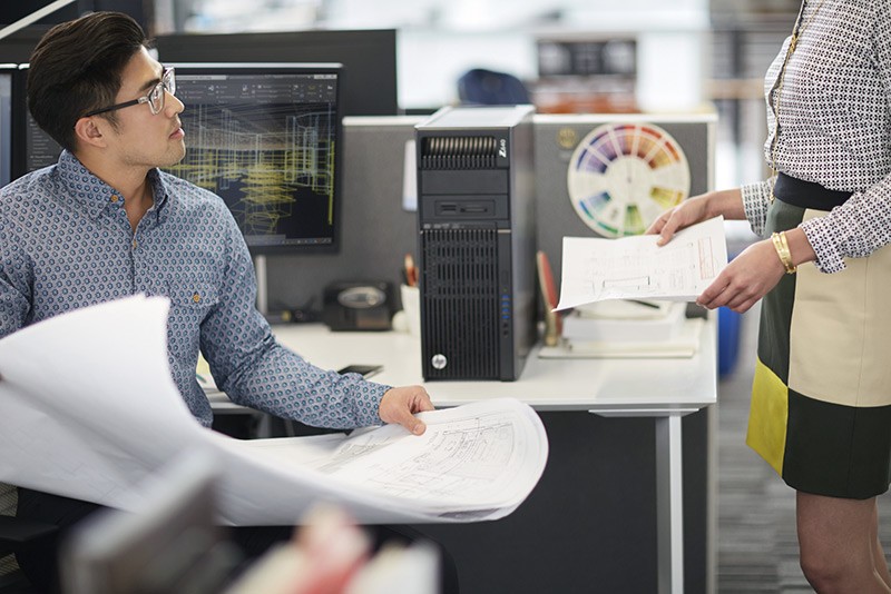 A man and woman discuss architectural plans while using HP Z27s 27&quot; IPS Ultra HD Displays with a HP Z640 Workstation.