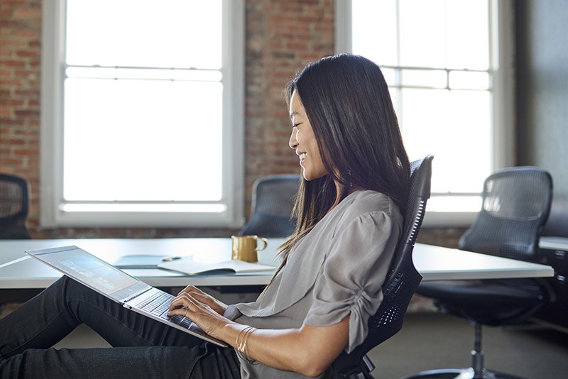 A woman using a HP EliteBook Folio G1 while at work. 