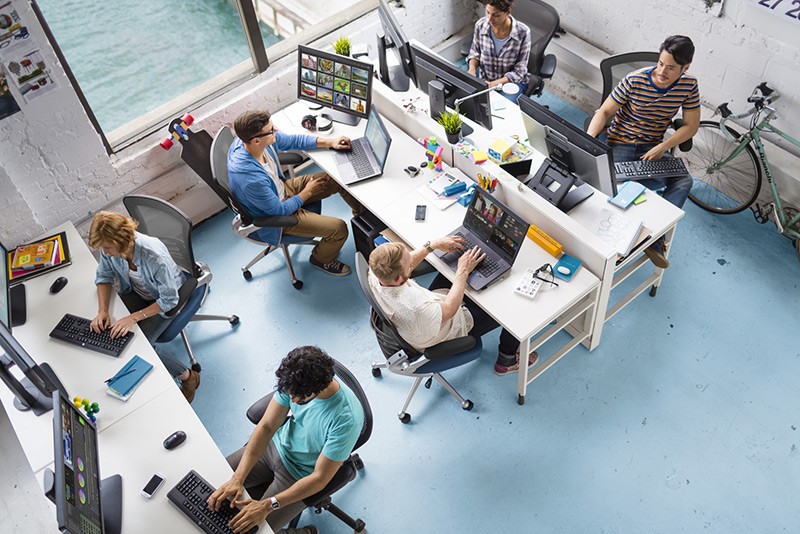Overhead view of creative professionals working in an office with various HP workstations and displays.