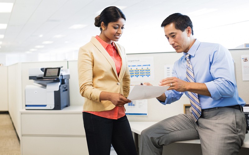 Business professionals have a discussion near a HP LaserJet Enterprise color flow MFP M575c