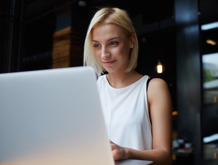 Business woman sitting at the table working off her laptop computer