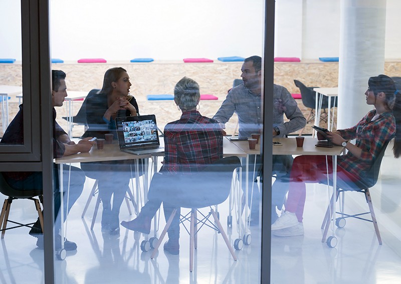 Business team having a brainstorming session, while working on laptop and tablet computers