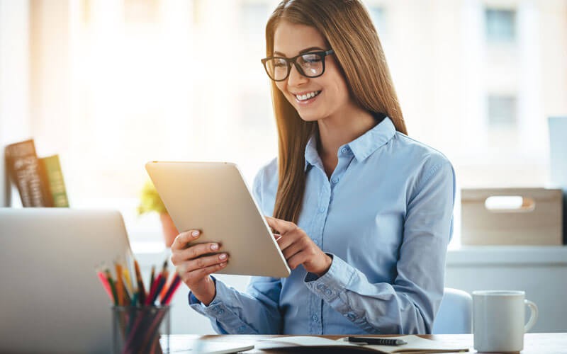 Woman smiling while using tablet device