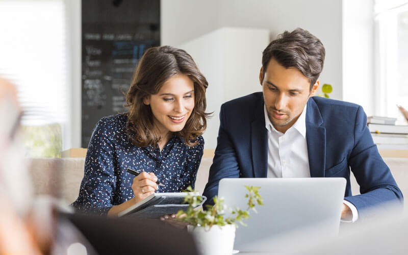 Man and woman collaborating over laptop device
