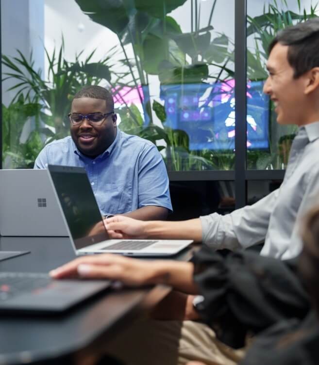 coworkers at a meeting with microsoft laptops