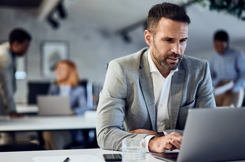 Businessman on laptop computer in office, Insight Flex for Devices, MDaaS