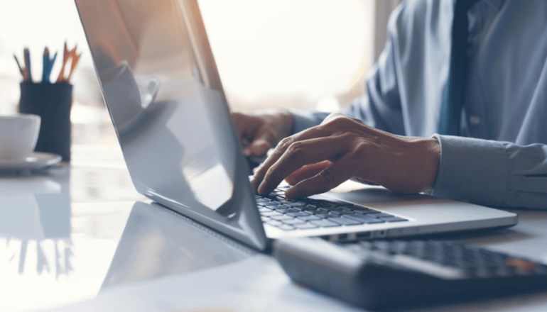 Don't wait until the last moment to migrate to Windows 11 Business professional typing on laptop keyboard