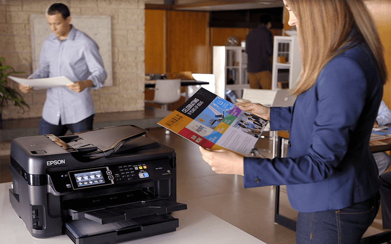 Epson printers to solve even your most industry-specific printing challenges Woman working at Epson printer in open office