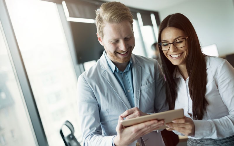 Nutanix hyperconverged enterprise application solutions Two professionals smiling over tablet device