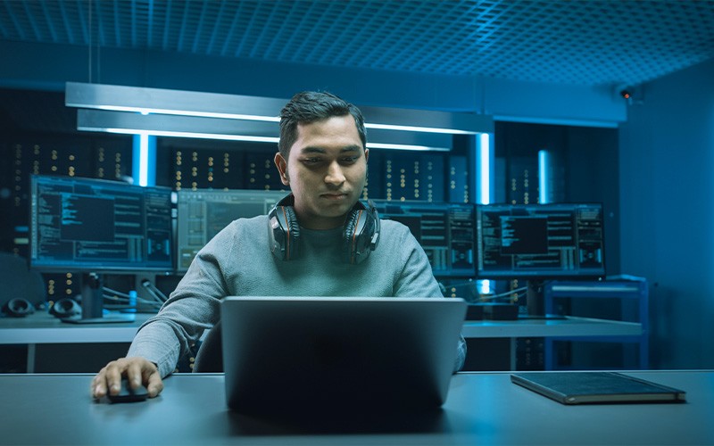 man wearing headset while using laptop