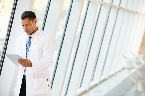 Doctor on tablet in hallway of hospital