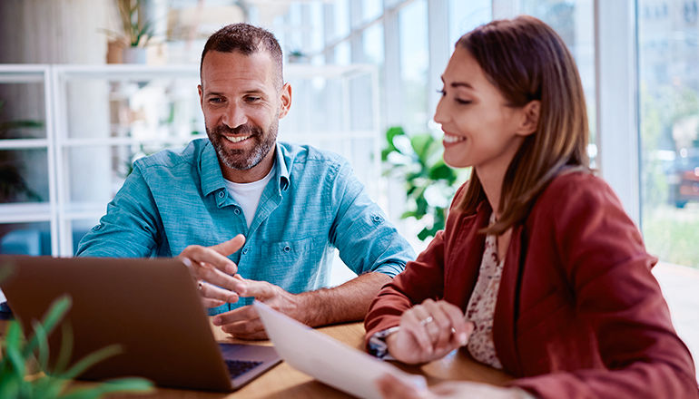 Demystifying Zero Trust and AI woman showing laptop to male colleague
