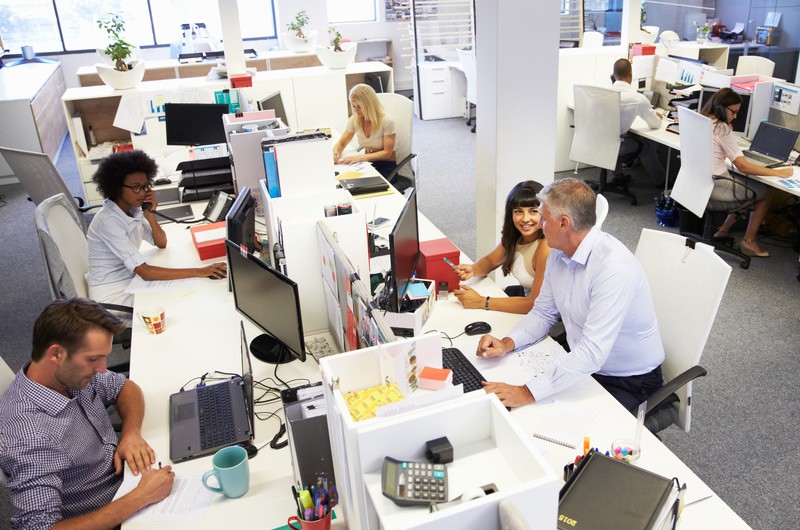Birds eye view of busy office with workers working on their computers.