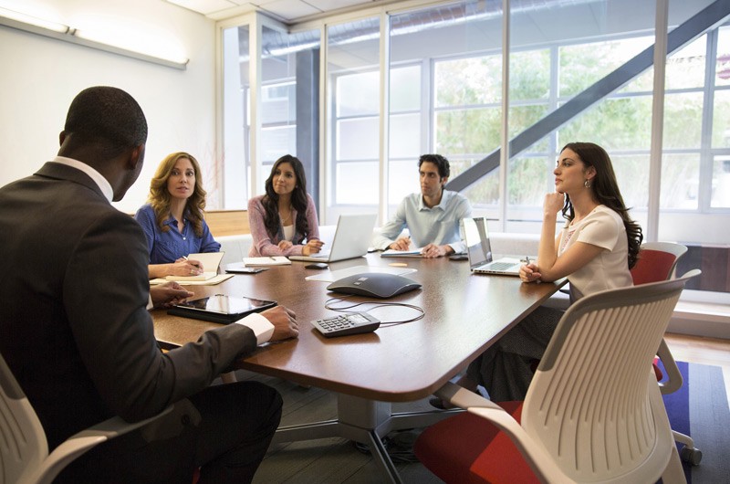 Conference room with business people discussing services.