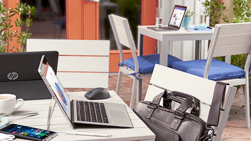 Protect your technology while on the go HP Elite x2 1012 Tablet, HP S140u Display, HP Elite Thunderbolt Dock, Wireless Mouse, HP Elite top Load Colombian Leather Case, HP EliteBook Folio G1 at outdoor cafe