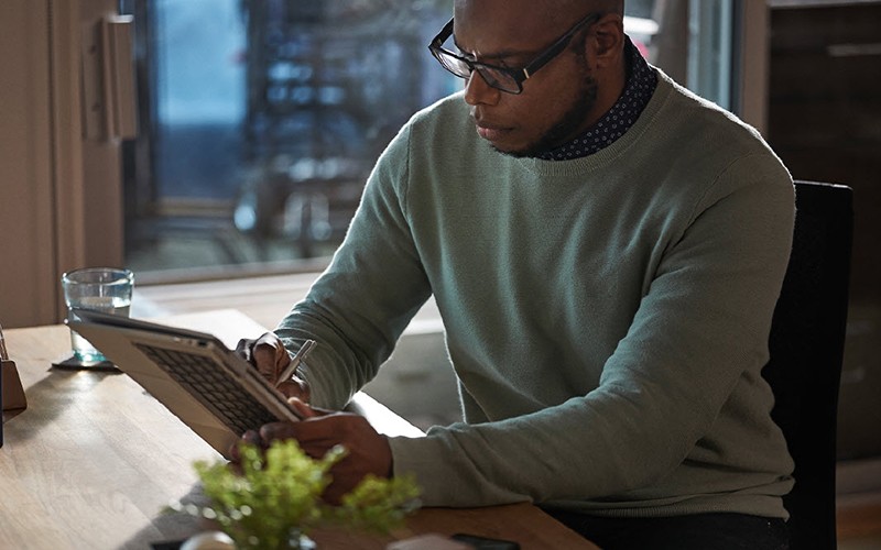 Man using stylus to write on his laptop