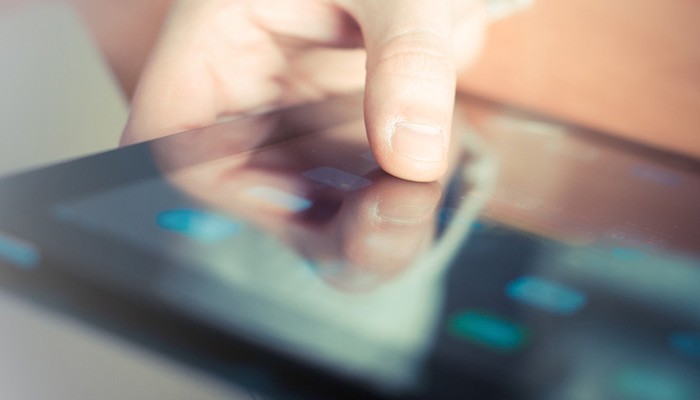 User pressing onto the display screen of a tablet computer