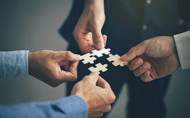 people holding puzzle pieces