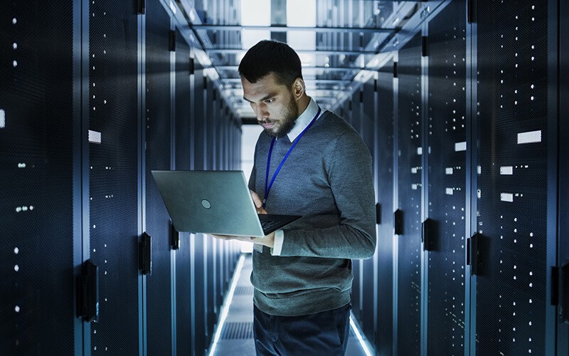Person using a laptop inside of data center