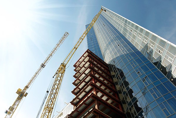 cranes-building-glass-skyscraper